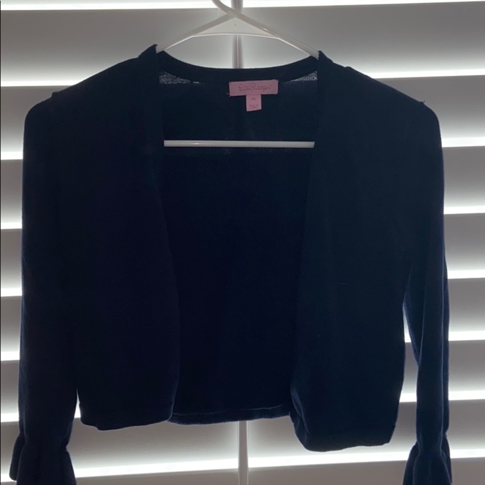 Lilly puts a navy blue cardigan
